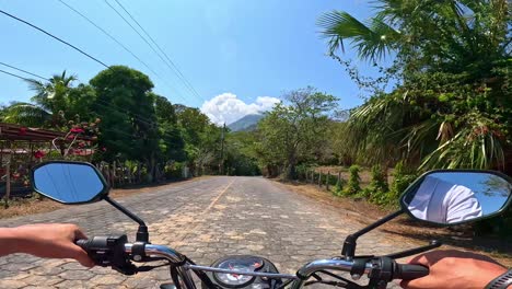 a man's pov riding a motorbike towards a volcano