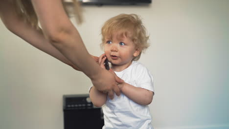 toddler puts to ear, walks