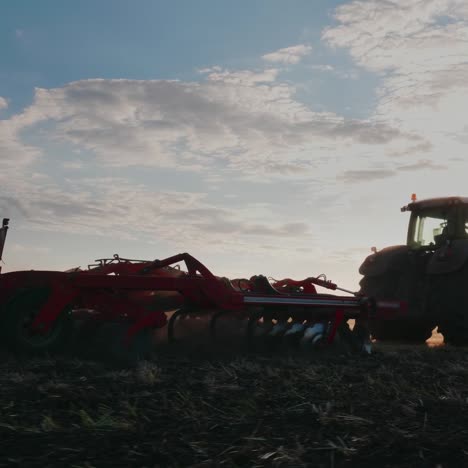 tractor con taladro pasa por el campo