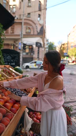 woman shopping for fruit at a street market