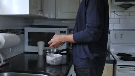 cropped view of a man peeling boiled egg in the kitchen