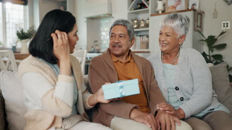 Birthday,-gift-and-senior-parents-on-sofa