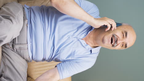 Vertical-video-of-Old-man-talking-on-the-phone-with-a-happy-expression.