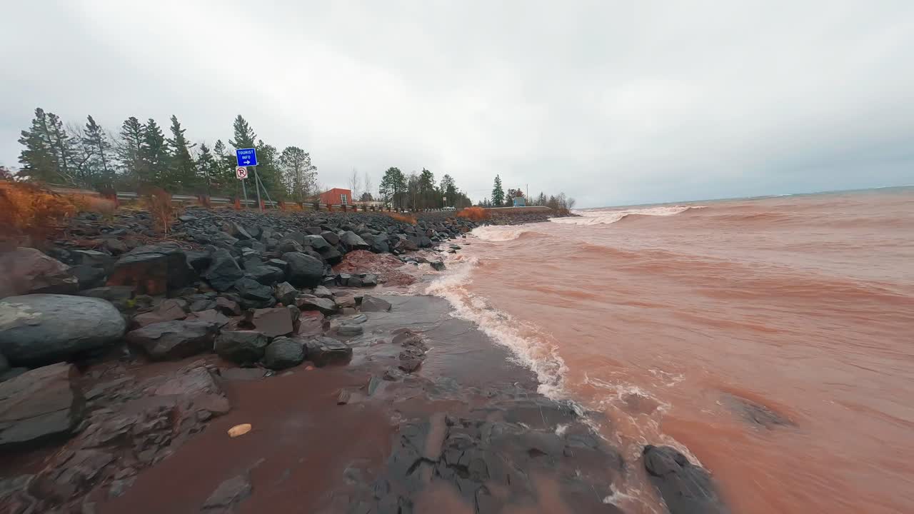 toma aérea dramática a lo largo de la costa del lago superior en minnesota mientras una tormenta sopla olas en la costa