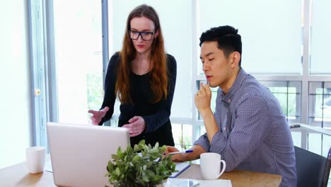 business executives discussing over laptop