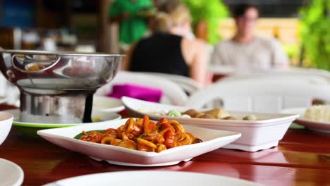 una vibrante escena gastronómica en krabi, tailandia, mostrando deliciosos calamares fritos con huevo salado en medio de una animada atmósfera de restaurante