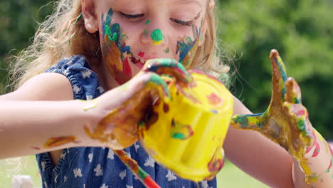 a little girl playing with paint outdoors