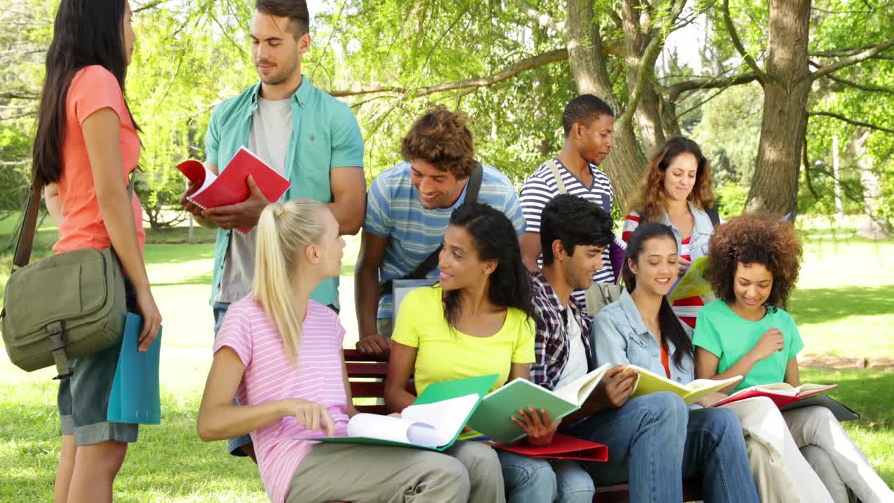 estudiantes leyendo y charlando juntos afuera en el campus