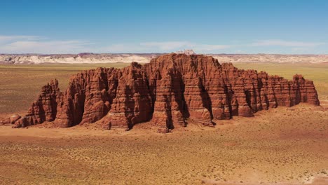 Elevated-aerial-panning-around-massive-red-rock-formation-in-Utah-desert,-US