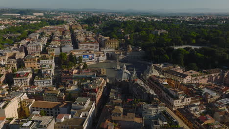 Volar-Sobre-El-Centro-Histórico-De-La-Ciudad.-Antiguos-Edificios-De-Varios-Pisos-Con-Terrazas-En-La-Azotea,-Plaza-Ovalada-Piazza-Del-Popolo-Con-Obelisco-Egipcio.-Roma,-Italia