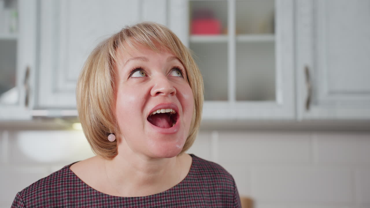 primer plano de una mujer de mediana edad observando atentamente una olla en la mano con una expresión cálida y contenta, iluminación suave y armarios de cocina modernos en el fondo