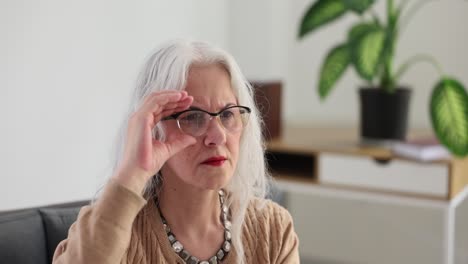 elderly woman adjusting her glasses to improve vision