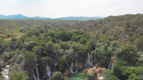 drone shot of gorgeous hidden waterfalls with small recreation center in bosnia and herzegovina