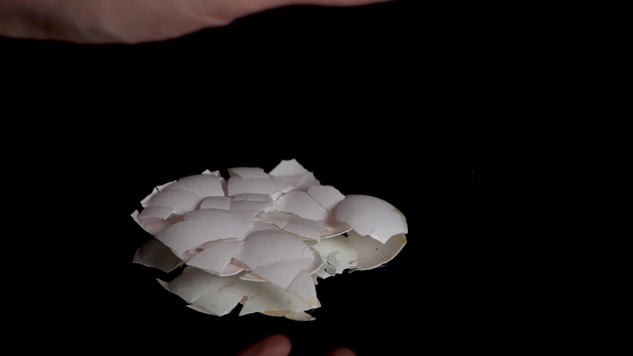 用光手在慢动作中粉碎空蛋壳的中等镜头