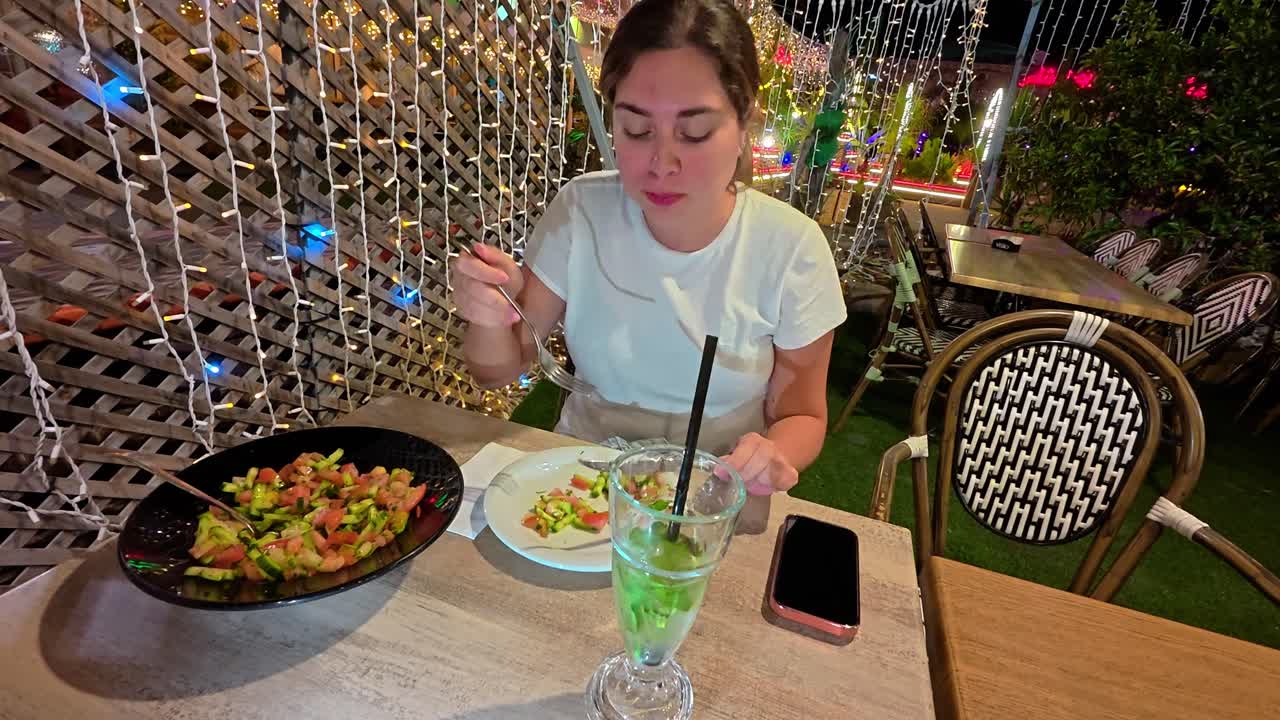 A Woman Enjoying a Healthy Salad Dinner Outdoors at Night