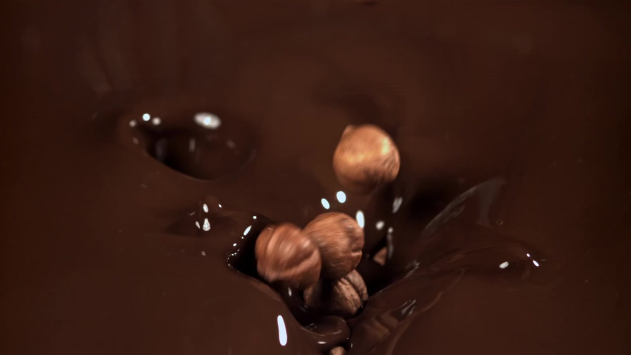 Nocciole che Cadono nel Cioccolato Fuso al Rallentatore