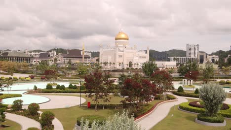 tomada panorámica de los jardines tropicales y el paisajismo hermoso frente a la mezquita del sultán omar ali saifuddien en bandar seri bagawan en brunei darussalam