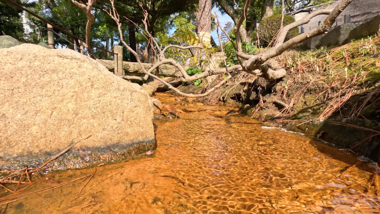 Clear water stream flowing by a stationary rock