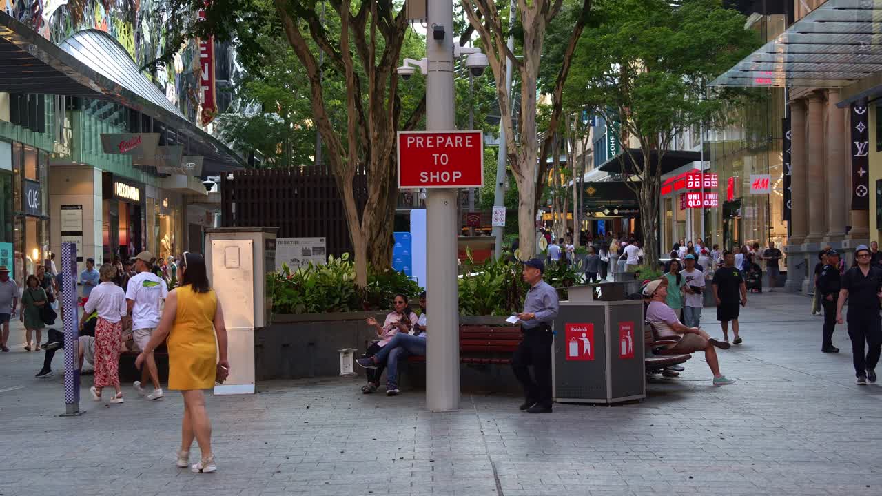 Vibrant urban street scene of downtown Brisbane city on the weekend, shoppers shopping at Queen street mall, an outdoor pedestrian shopping precinct featuring Prepare To Shop sign.