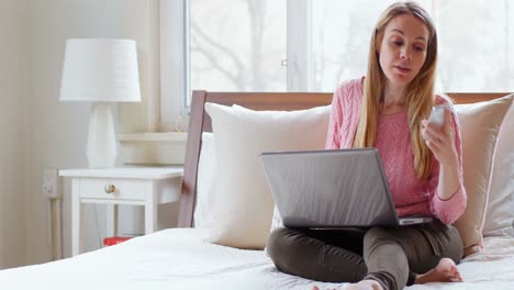 Mujer-Madura-Usando-Laptop-Mientras-Habla-Por-Teléfono-Móvil-4k