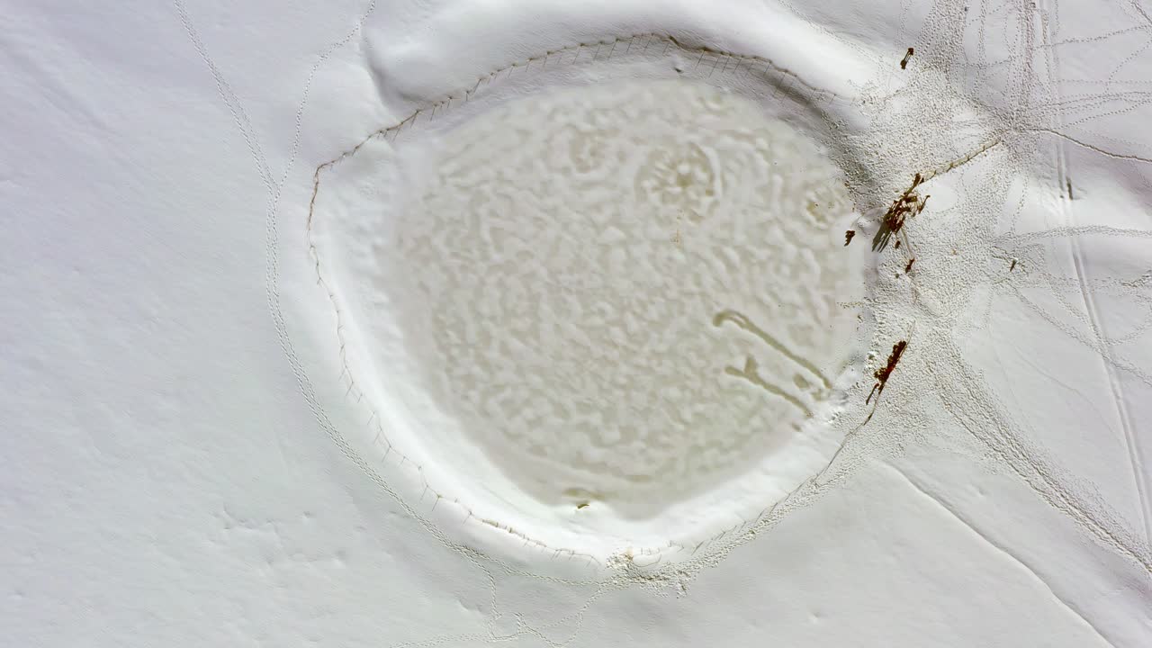 rotación aérea de arriba hacia abajo del lago ram o birkat ram en la nieve en el monte hermón, israel, la montaña y el lago se encuentran en las alturas del golán nororiental