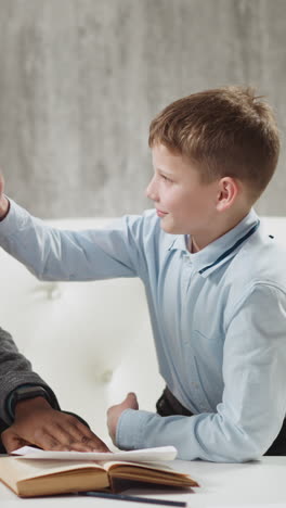 cheerful african-american tutor gives high five and shows thumb-up praising junior boy student at private english tuition with native speaker slow motion