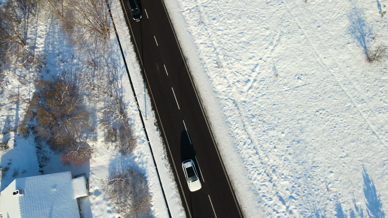 coches conduciendo por una pintoresca carretera asfaltada con un paisaje nevado en gdansk, polonia, en un soleado día de invierno