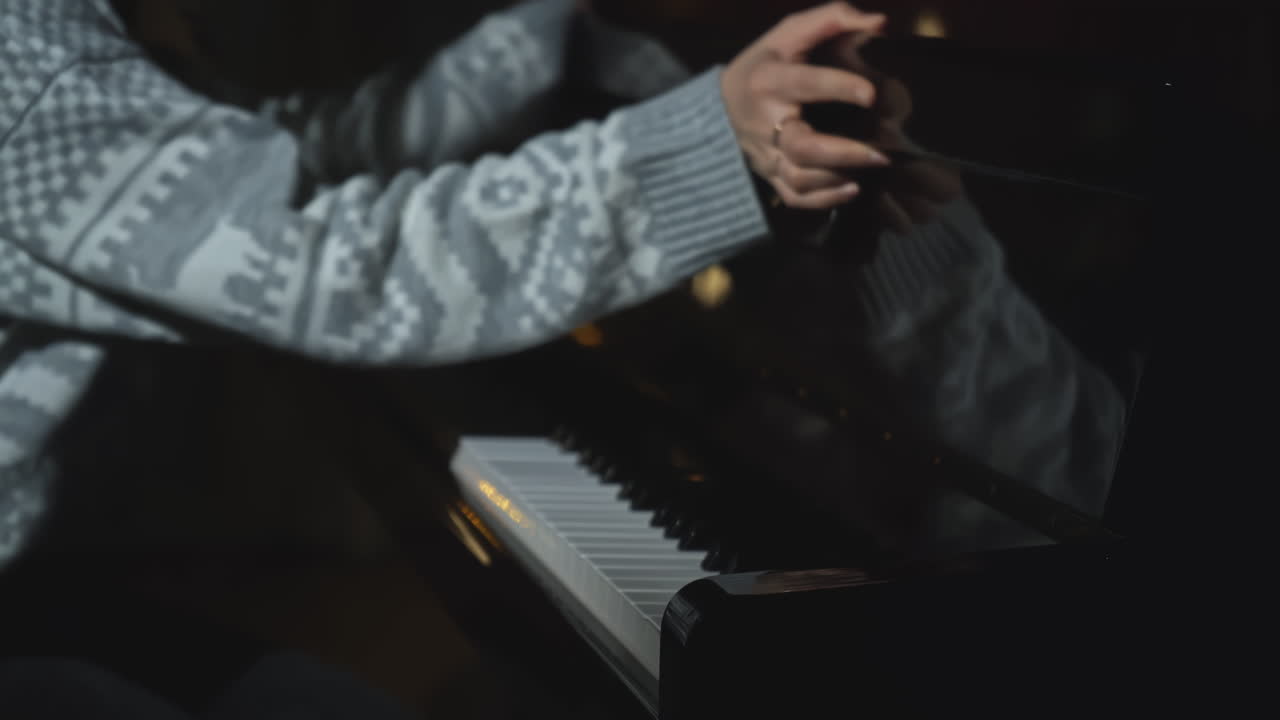 mujer tocando el piano en la oscuridad