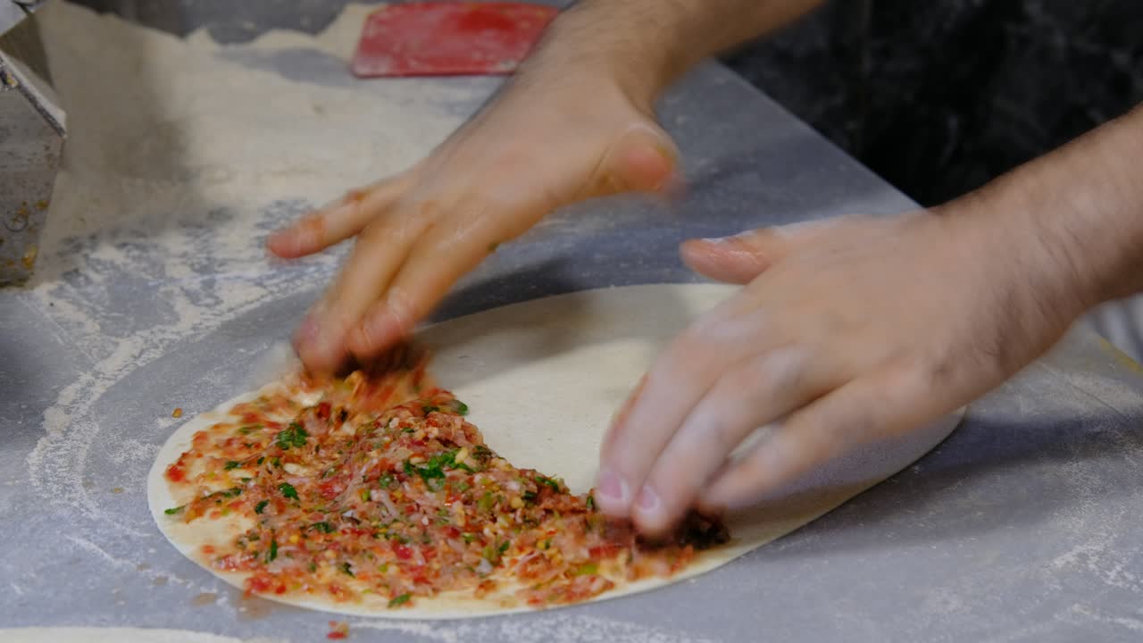 manos masculinas haciendo lahmacun