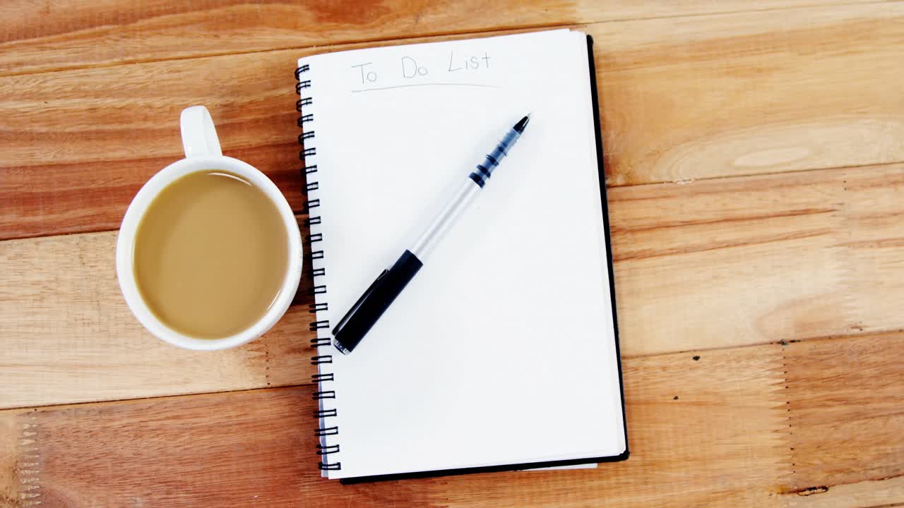 Cup of coffee with diary and pen