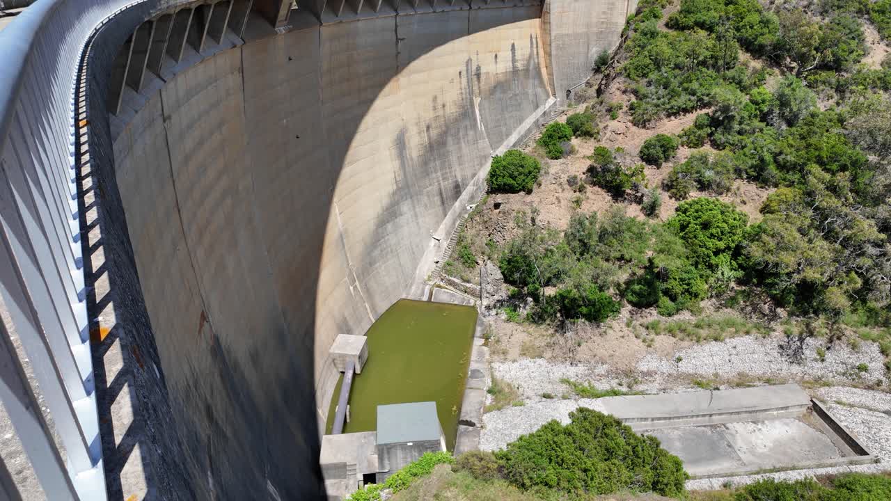 Bravura Dam wall curving under a clear blue sky in the sunny Portugal countryside