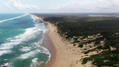 tiro de vuelo hacia adelante a gran altitud de la playa de chidenguele en mozambique con el lago inhampavala en el fondo