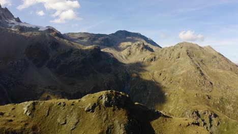 Sombras-De-Nubes-Sobre-El-Paisaje-Montañoso-Con-Colores-Otoñales-Arolla,-Valais---Suiza