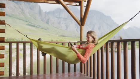 caucasian woman having a good time on a trip to the mountains, using a tablet and smiling