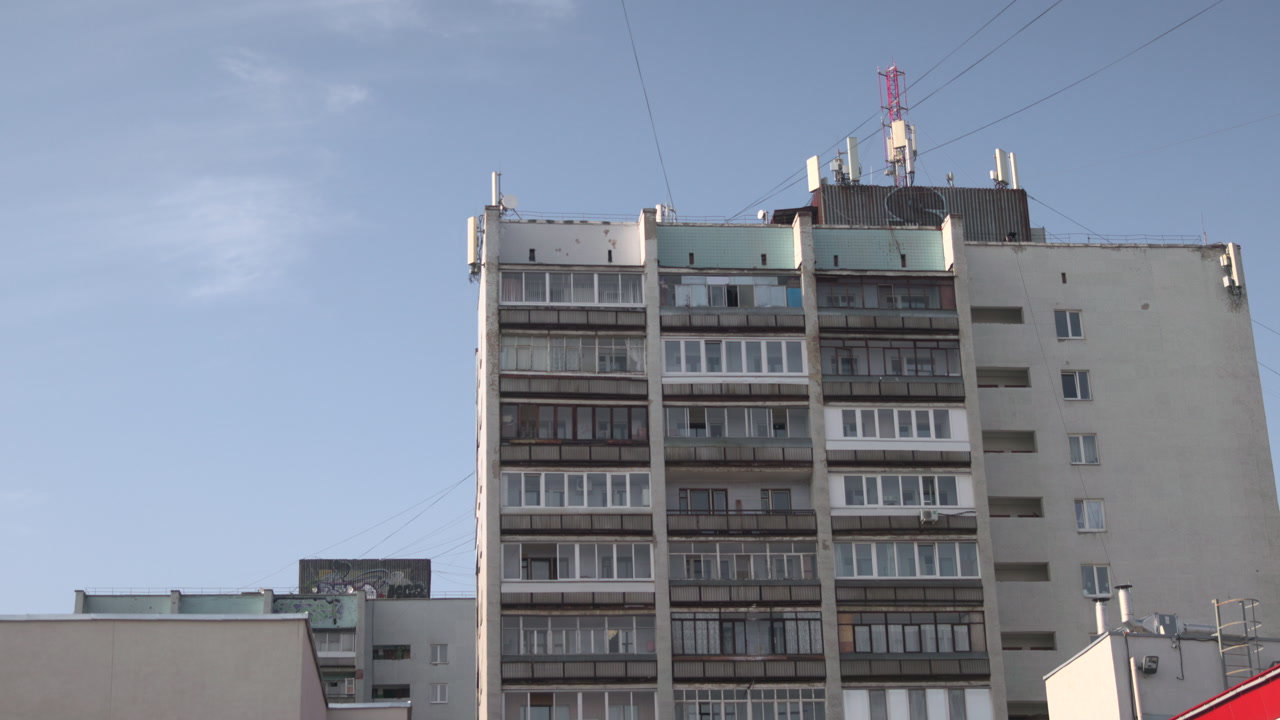 Concrete Tower Under Clear Blue Sky Stacked Balconies And Grid Like Windows Weathered Facade With Rooftop . Media