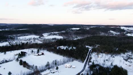 Zona-Rural-Del-Estado-De-Nueva-York-Con-Nieve-Ligera-Al-Anochecer-En-Invierno,-Tomas-Aéreas-De-Drones-Vuelan-Lentamente-Sobre-Tierras-De-Cultivo