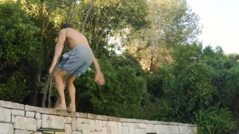 young man performing backflip stunt on swimming pool