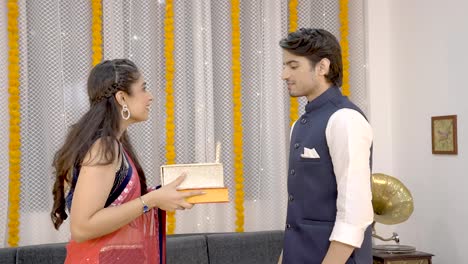 indian man giving gift boxes to his wife
