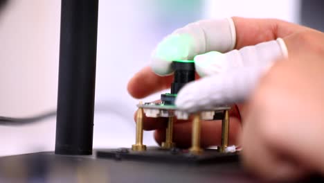 the engineer places the motherboard under the magnifying glass