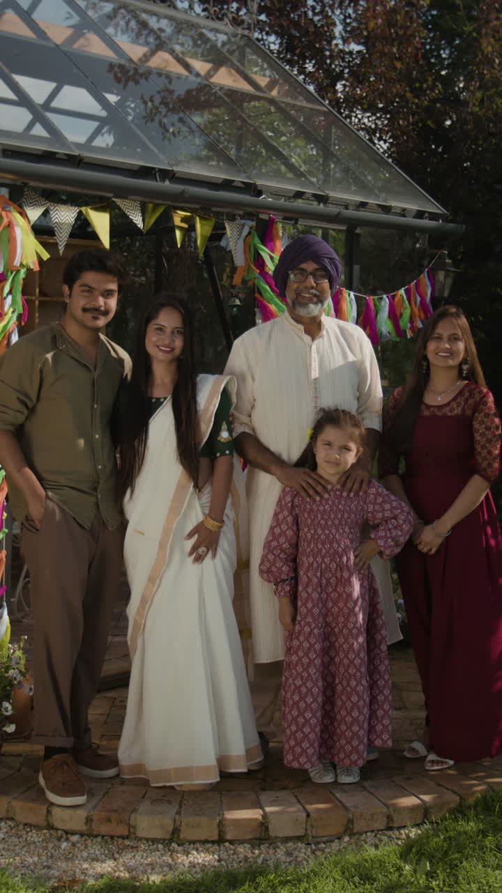 A multi-generational South Asian family poses for a portrait in a decorated garden