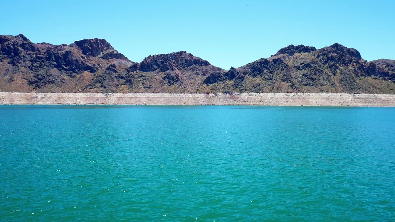 Panning shot of bathtub ring clearly visable on rocks and mountain sides around Lake Mead