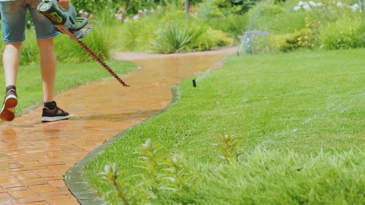 손에 장비를 들고 정원을 걸어다니는 정원사: 시골 생활, 과일 재배, 정원 가꾸기의 개념.