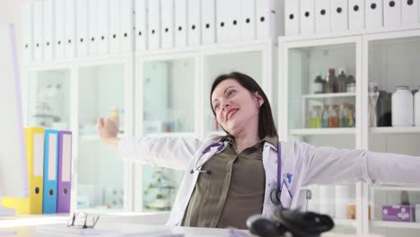 female doctor stretching and relaxing at her desk in the office