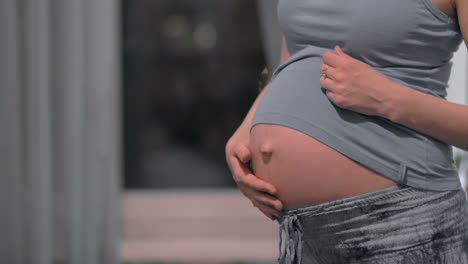 pregnant woman stroking and embracing the belly