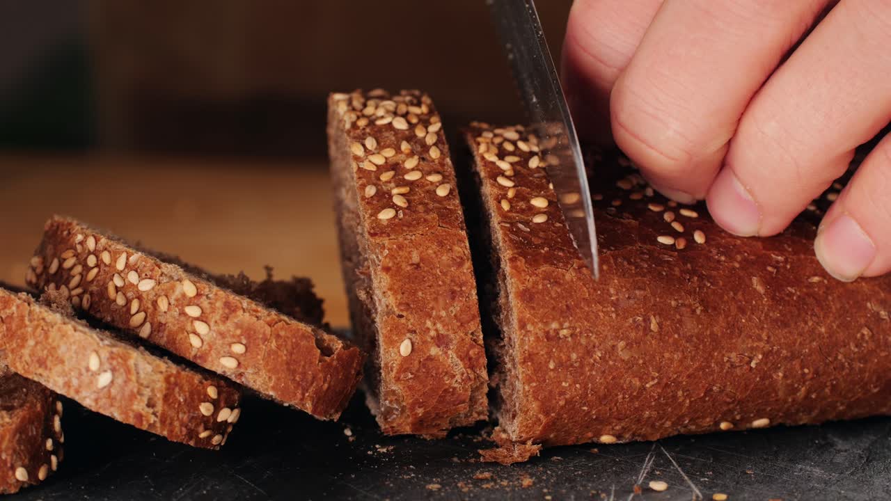 Slicing a loaf of sesame seed bread