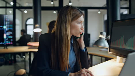 office businesswoman speaking cell at computer. finance manager planning stock