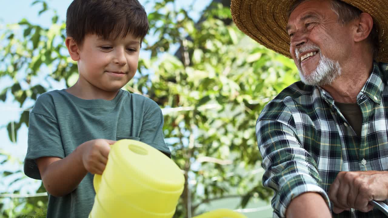 video de un nieto regando verduras con un riego amarillo