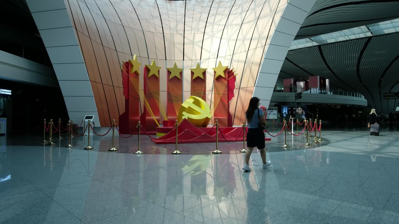 Beijing Daxing Airport Central Courtyard with Travelers Passing Communist Stars and Hammer and Sickle Symbol