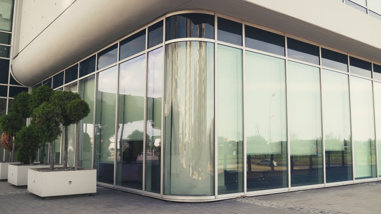 курьер по доставке еды в терморюкзаке едет на велосипеде рядом с офисным зданием, чтобы доставить заказы для клиентов и покупателей