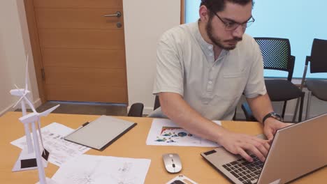 man working on laptop at office desk